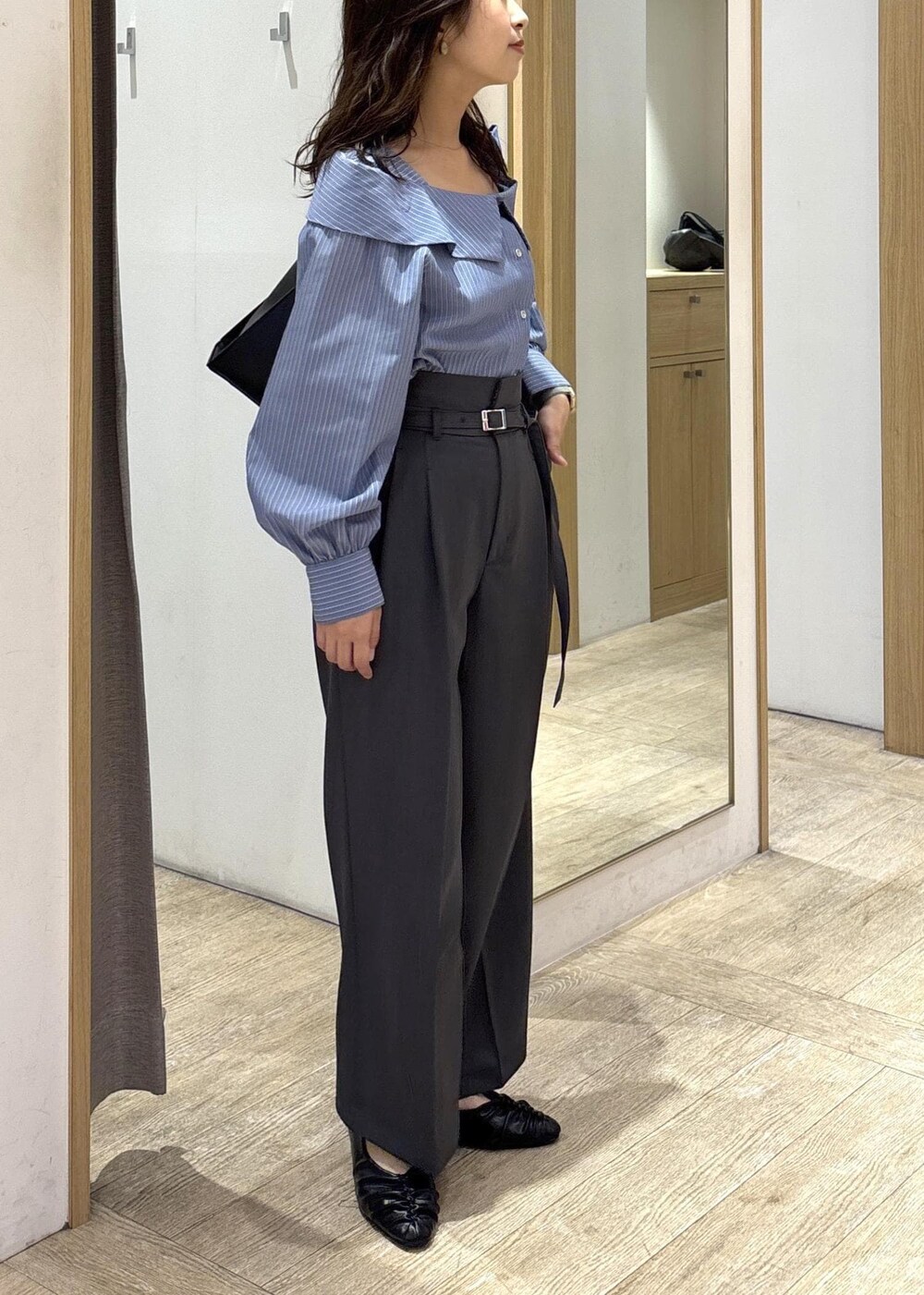 ブラック系のトートバッグ、ブラック系のパンプス、ブルー系のシャツ/ブラウスを着用したレディースの秋コーディネートの4枚目の写真