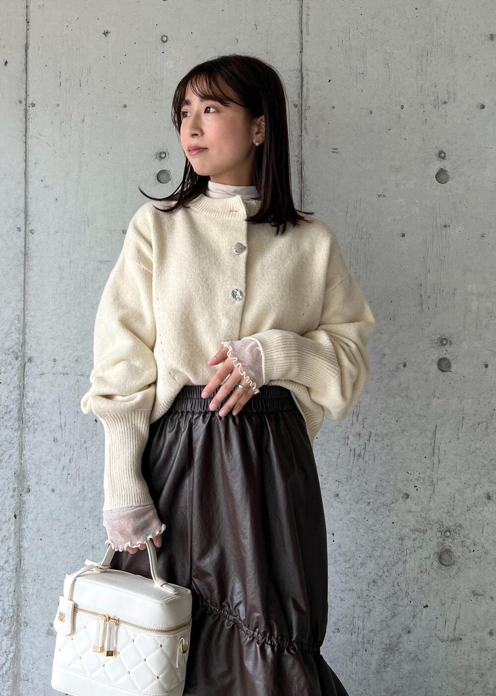 ブラウン系のスカート、ベージュ系のTシャツ/カットソー、ブラック系のパンプスを着用したレディースの冬コーディネートの6枚目の写真