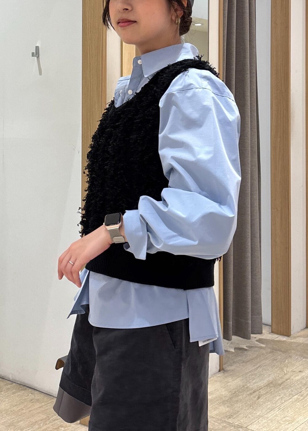 グレー系のショルダーバッグ、ブルー系のシャツ/ブラウス、ブラック系のベストを着用したレディースの秋コーディネートの6枚目の写真