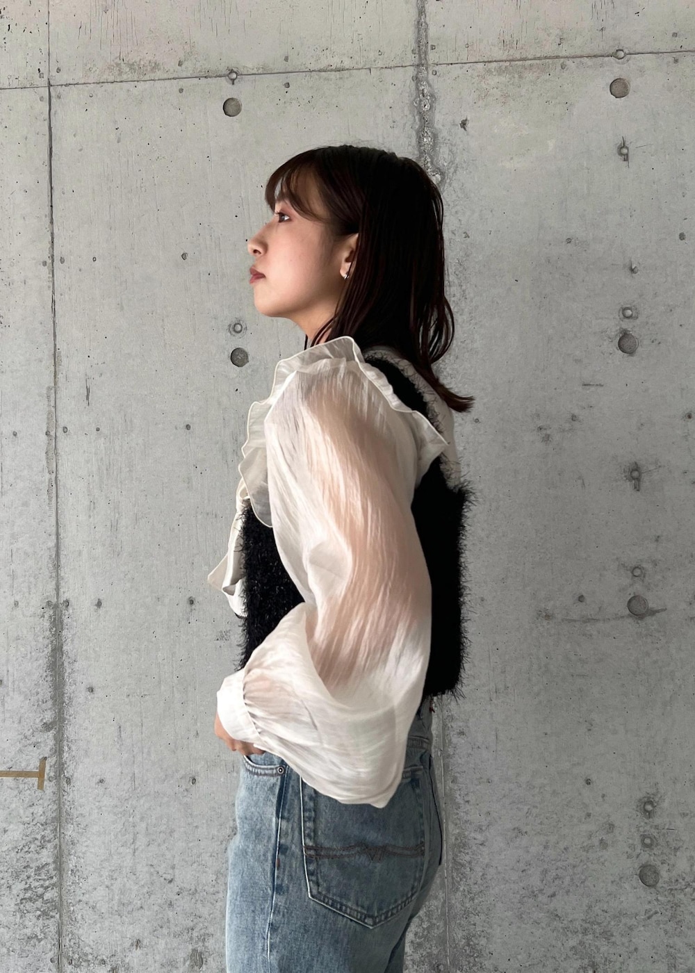 ブルー系のデニムパンツ、ブラック系のキャミソール、シルバー系のブーツを着用したレディースの秋コーディネートの7枚目の写真