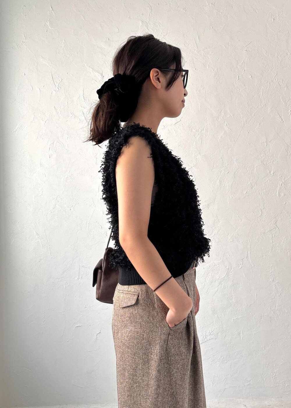 ブラック系のパンプス、ブラック系のベスト、ブラウン系のショルダーバッグを着用したレディースの夏コーディネートの8枚目の写真