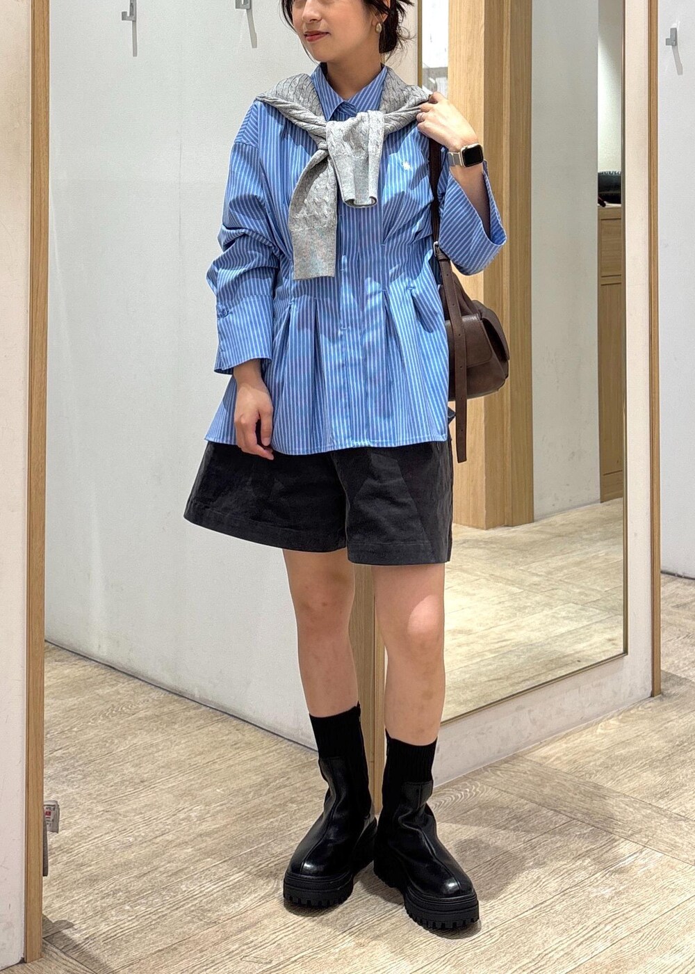 ブラック系のブーツ、ブルー系のシャツ/ブラウス、グレー系のカーディガン/ボレロを着用したレディースの秋コーディネートの9枚目の写真