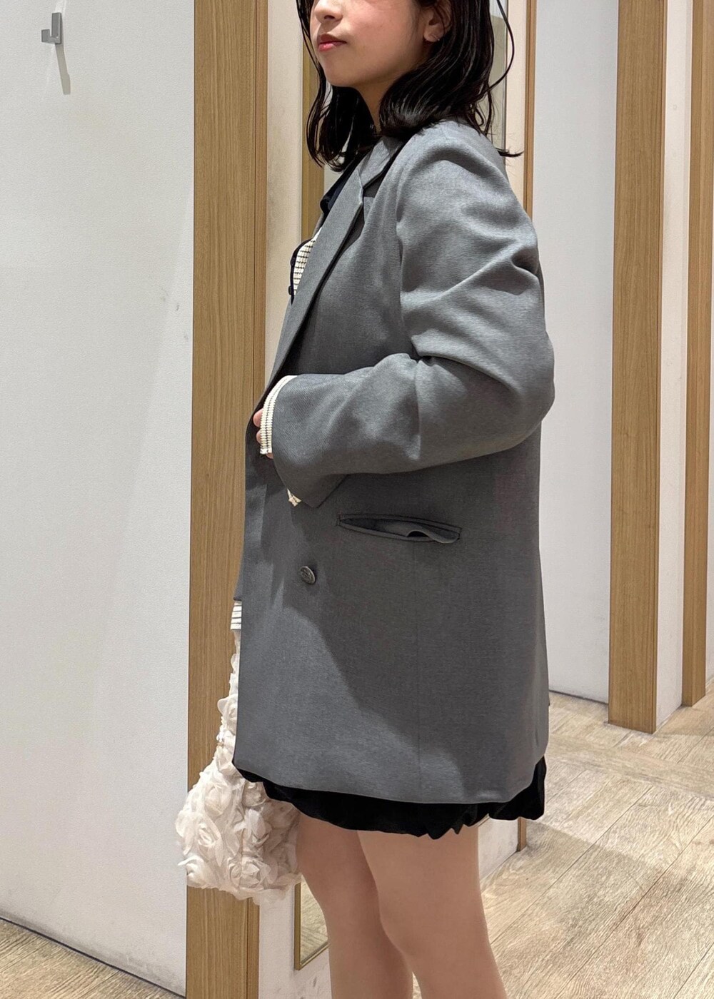 グレー系のテーラードジャケット、ブラック系のローファー、ブラック系のスカートを着用したレディースの春コーディネートの9枚目の写真