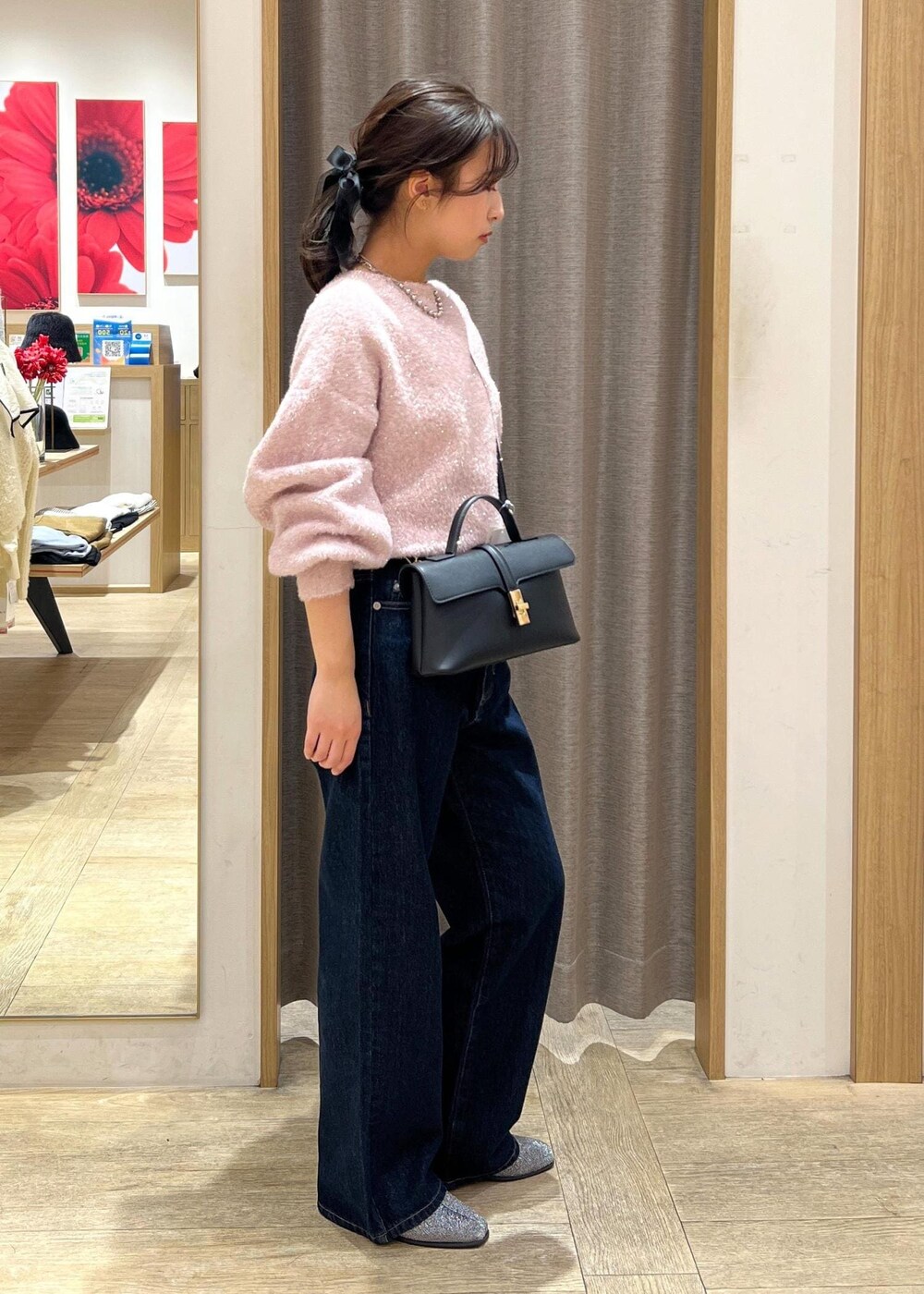 ブラック系のショルダーバッグ、シルバー系のブーツ、ブルー系のデニムパンツを着用したレディースの冬コーディネートの5枚目の写真