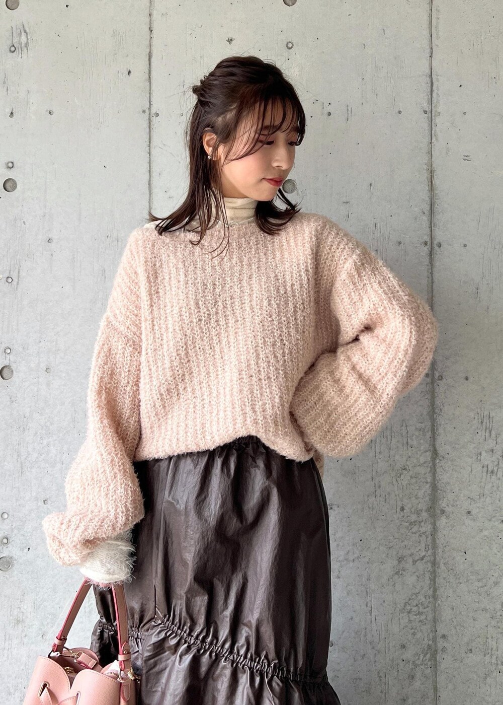 ピンク系のショルダーバッグ、ホワイト系のニット/セーター、ベージュ系のニット/セーターを着用したレディースの冬コーディネートの6枚目の写真