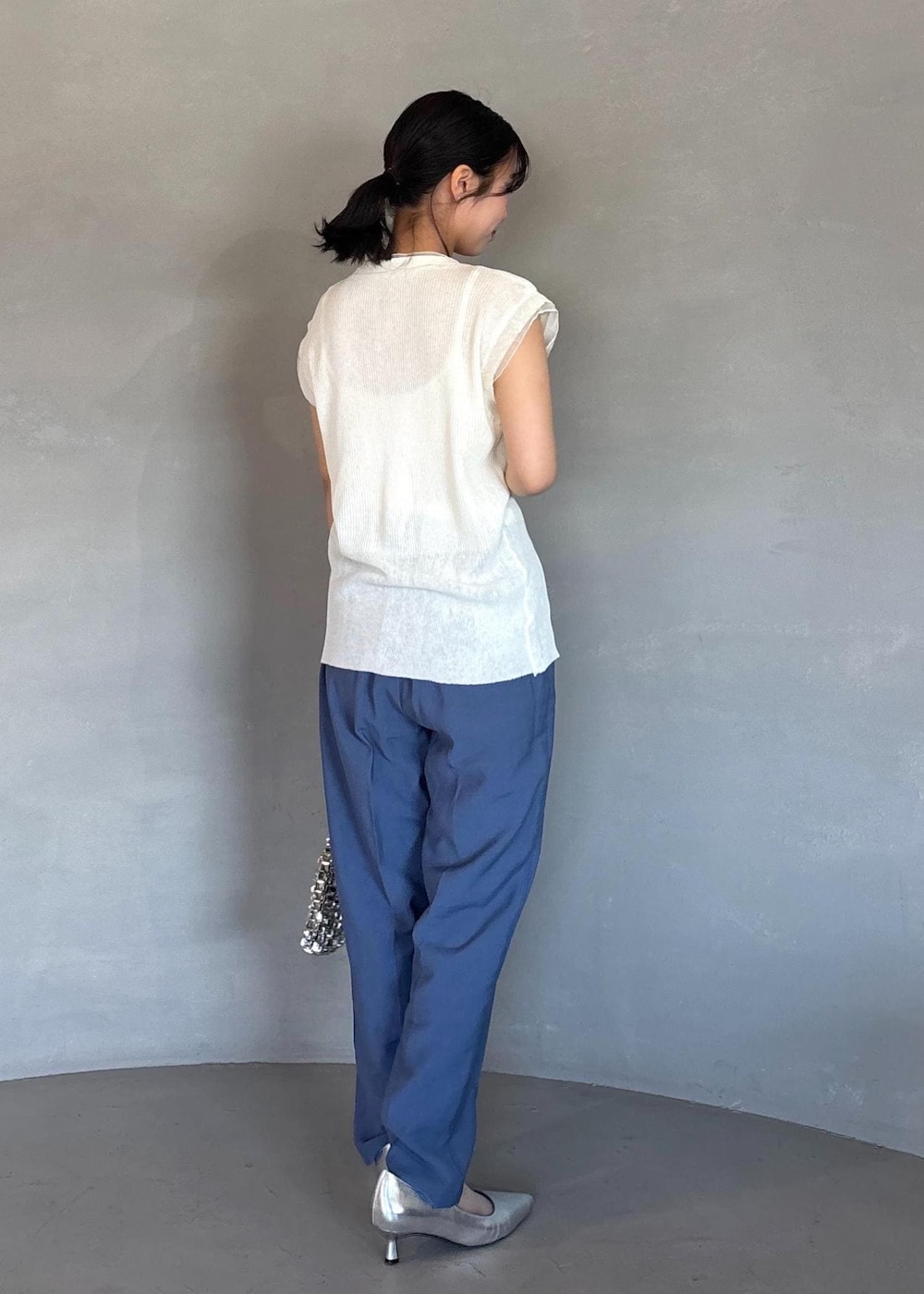 シルバー系のパンプス、ブルー系のその他パンツ、ホワイト系のベストを着用したレディースの春コーディネートの4枚目の写真