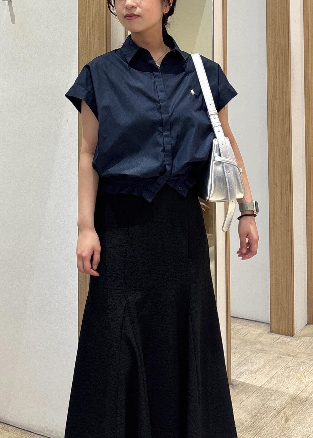 ホワイト系のキャミソール、シルバー系のパンプス、ブラック系のスカートを着用したレディースの春コーディネートの5枚目の写真