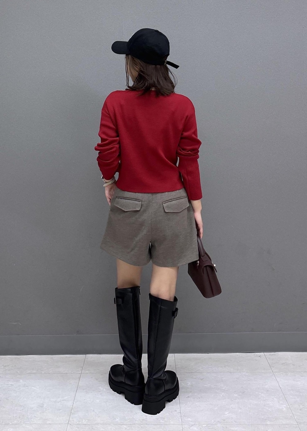 ブラック系のブーツ、レッド系のニット/セーター、ブラウン系のその他パンツを着用したレディースの秋コーディネートの3枚目の写真