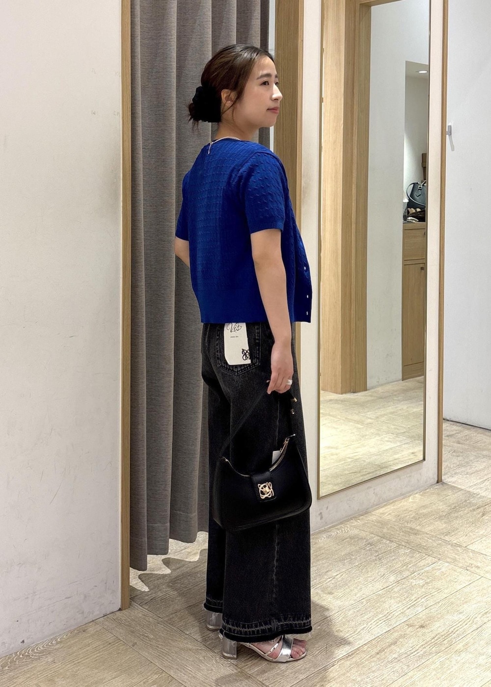 ブラック系のショルダーバッグ、ブラック系のデニムパンツ、ホワイト系のTシャツ/カットソーを着用したレディースの春コーディネートの5枚目の写真