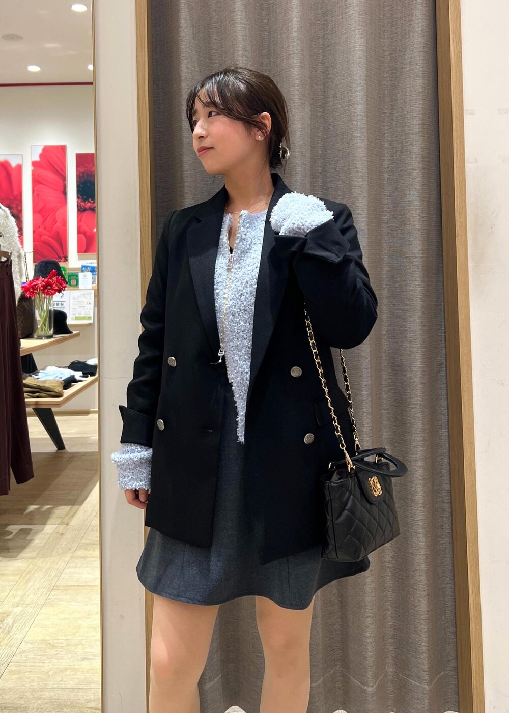 ブラック系のテーラードジャケット、ブラック系のスニーカー、ブルー系のカーディガン/ボレロを着用したレディースの冬コーディネートの7枚目の写真