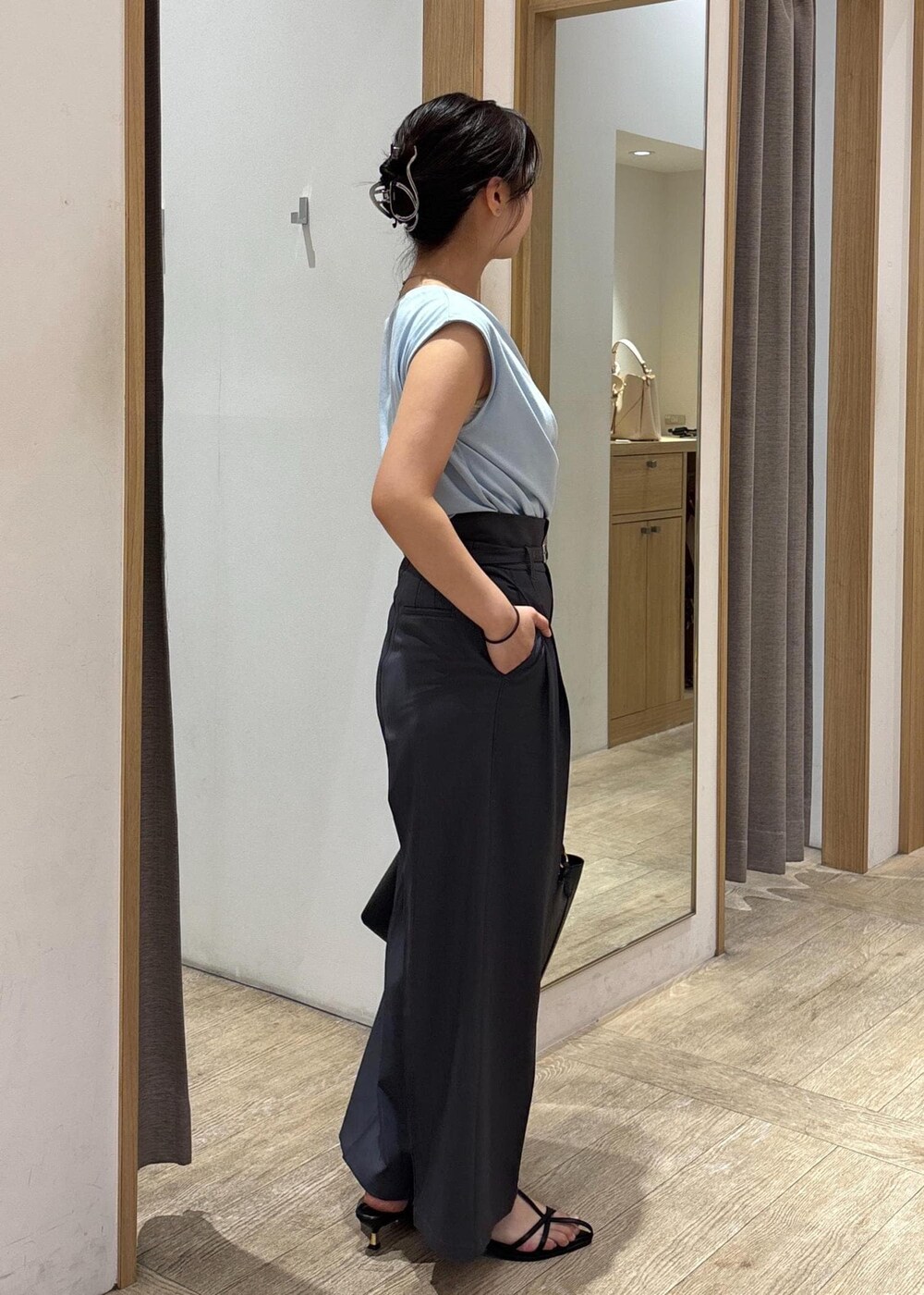 ブラック系のサンダル、ブルー系のTシャツ/カットソー、グレー系のスラックスを着用したレディースの夏コーディネートの3枚目の写真