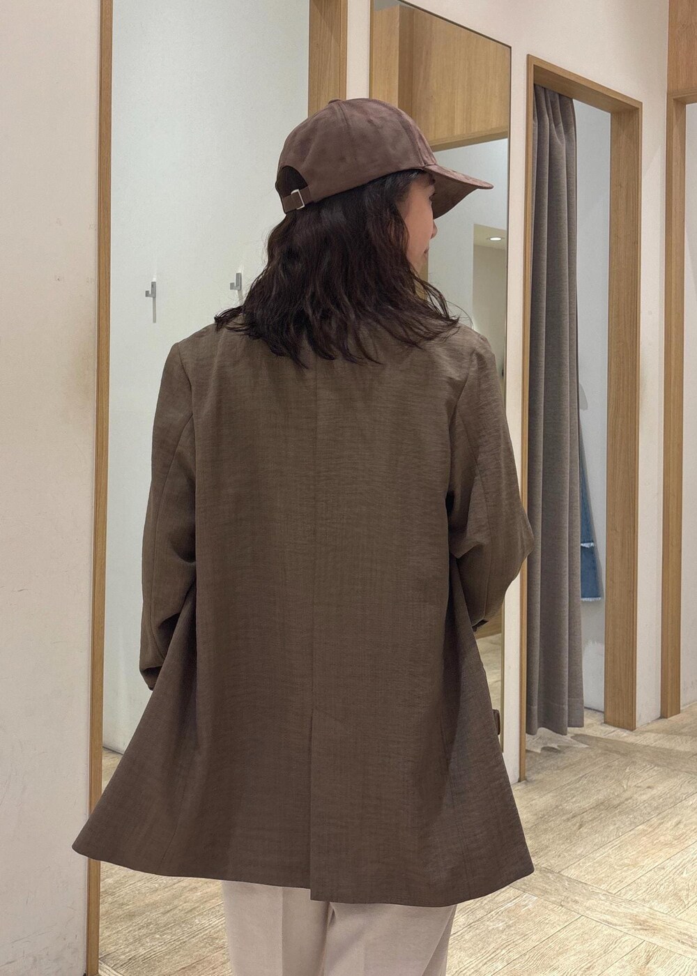 ブラウン系のショルダーバッグ、グリーン系のテーラードジャケット、ホワイト系のスラックスを着用したレディースの夏コーディネートの8枚目の写真