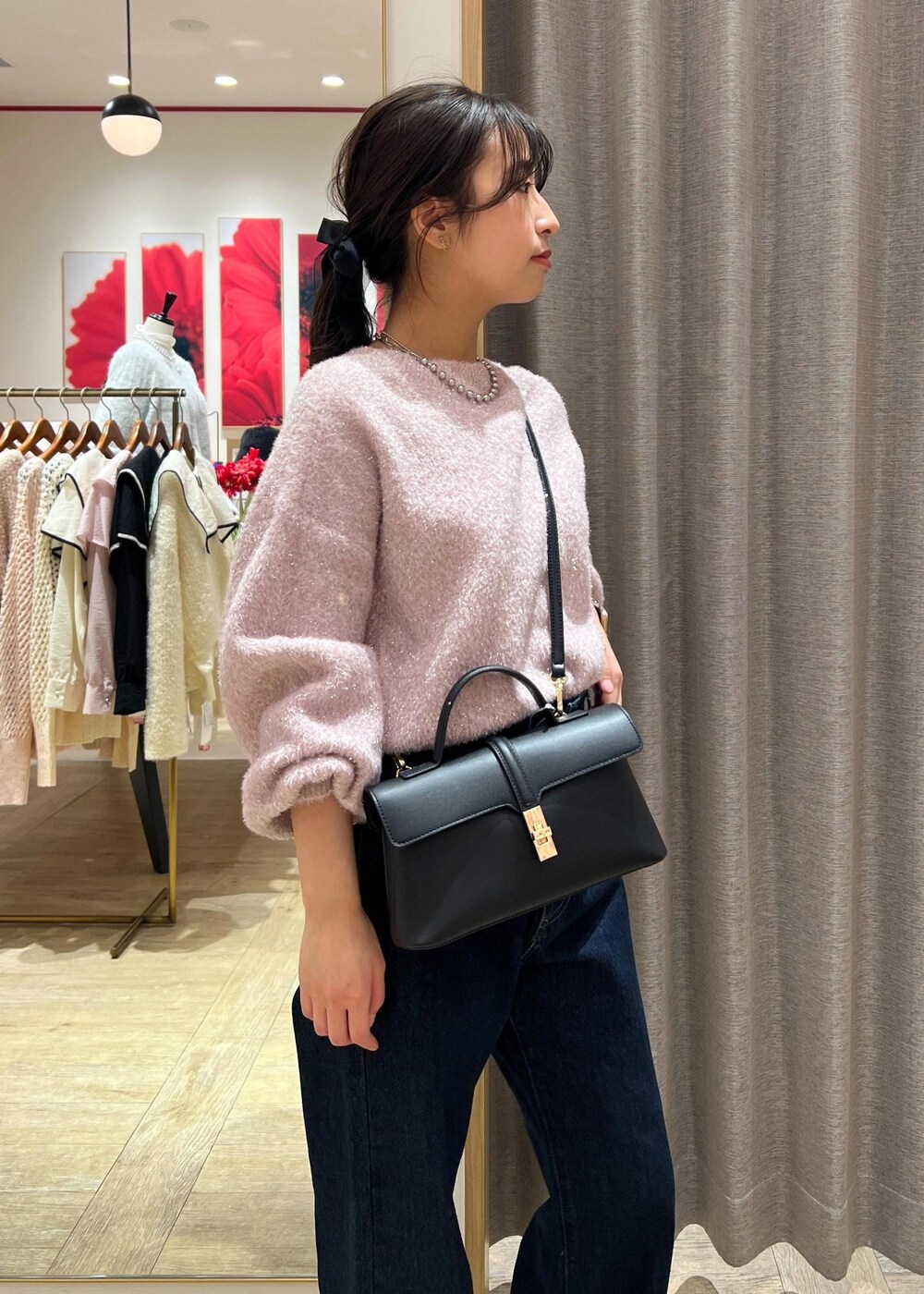 ブラック系のショルダーバッグ、シルバー系のブーツ、ブルー系のデニムパンツを着用したレディースの冬コーディネートの10枚目の写真