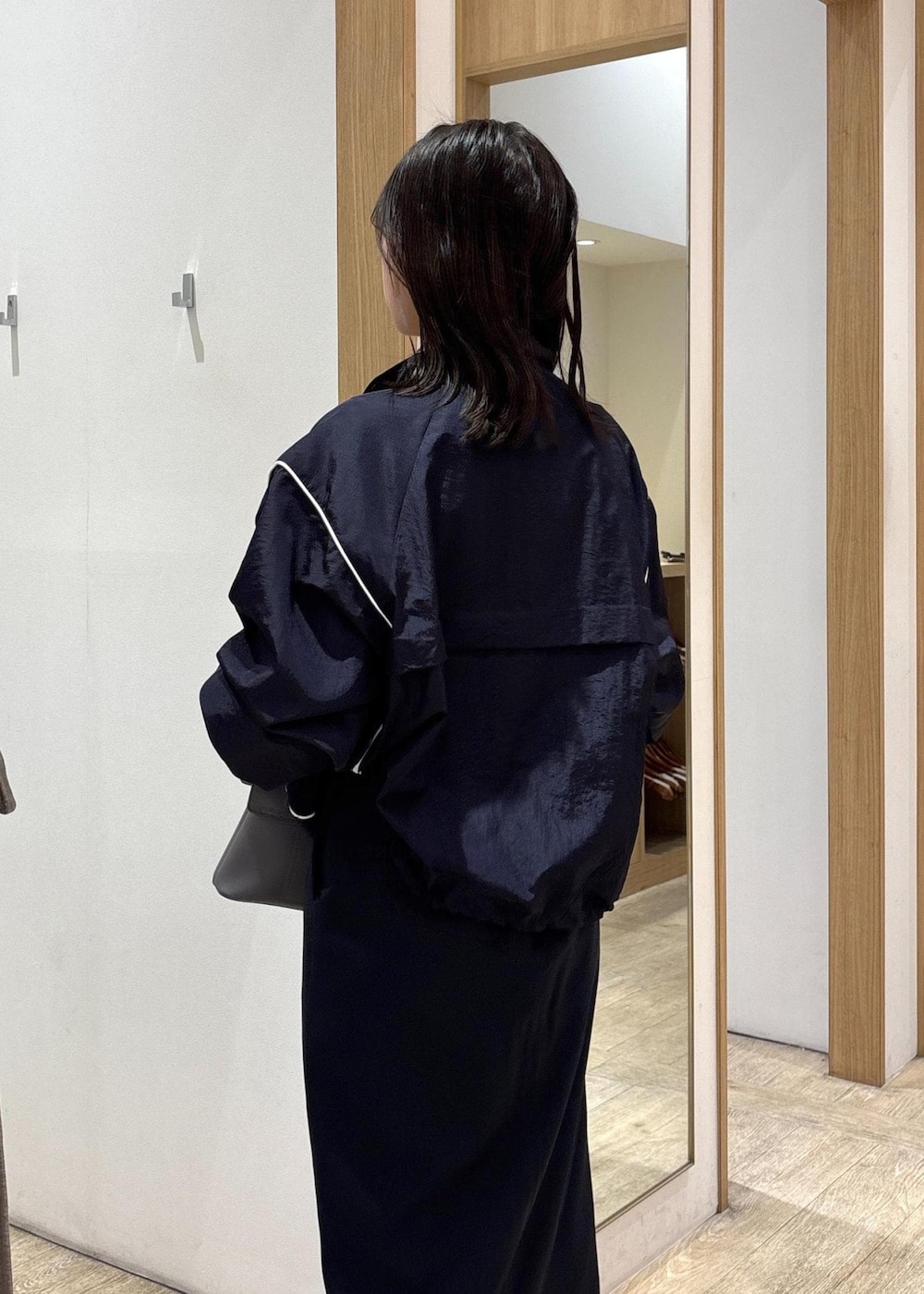 グレー系のショルダーバッグ、ブルー系のスカート、シルバー系のパンプスを着用したレディースの春コーディネートの8枚目の写真