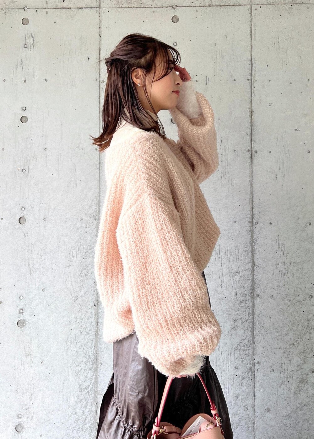 ピンク系のショルダーバッグ、ホワイト系のニット/セーター、ベージュ系のニット/セーターを着用したレディースの冬コーディネートの10枚目の写真