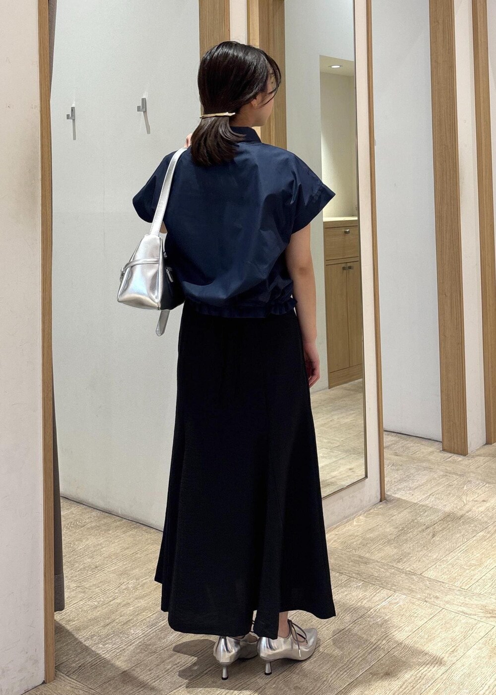 ホワイト系のキャミソール、シルバー系のパンプス、ブラック系のスカートを着用したレディースの春コーディネートの3枚目の写真