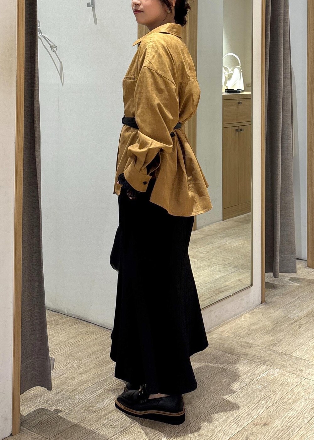 ブラック系のスカート、ブラック系のTシャツ/カットソー、ブラック系のハンドバッグを着用したレディースの秋コーディネートの2枚目の写真