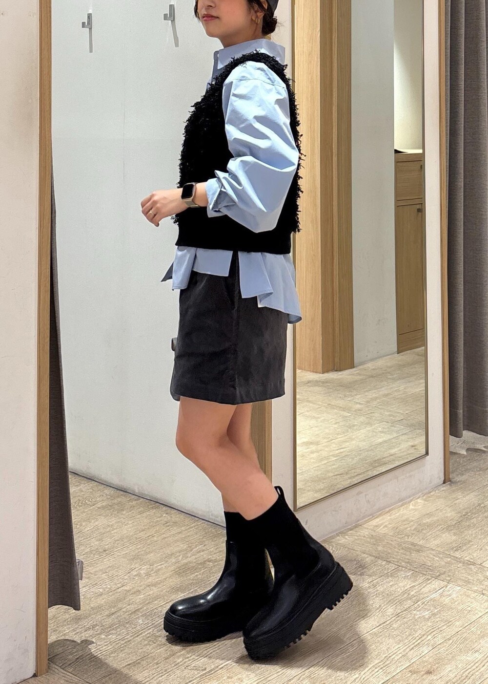 グレー系のショルダーバッグ、ブルー系のシャツ/ブラウス、ブラック系のベストを着用したレディースの秋コーディネートの2枚目の写真