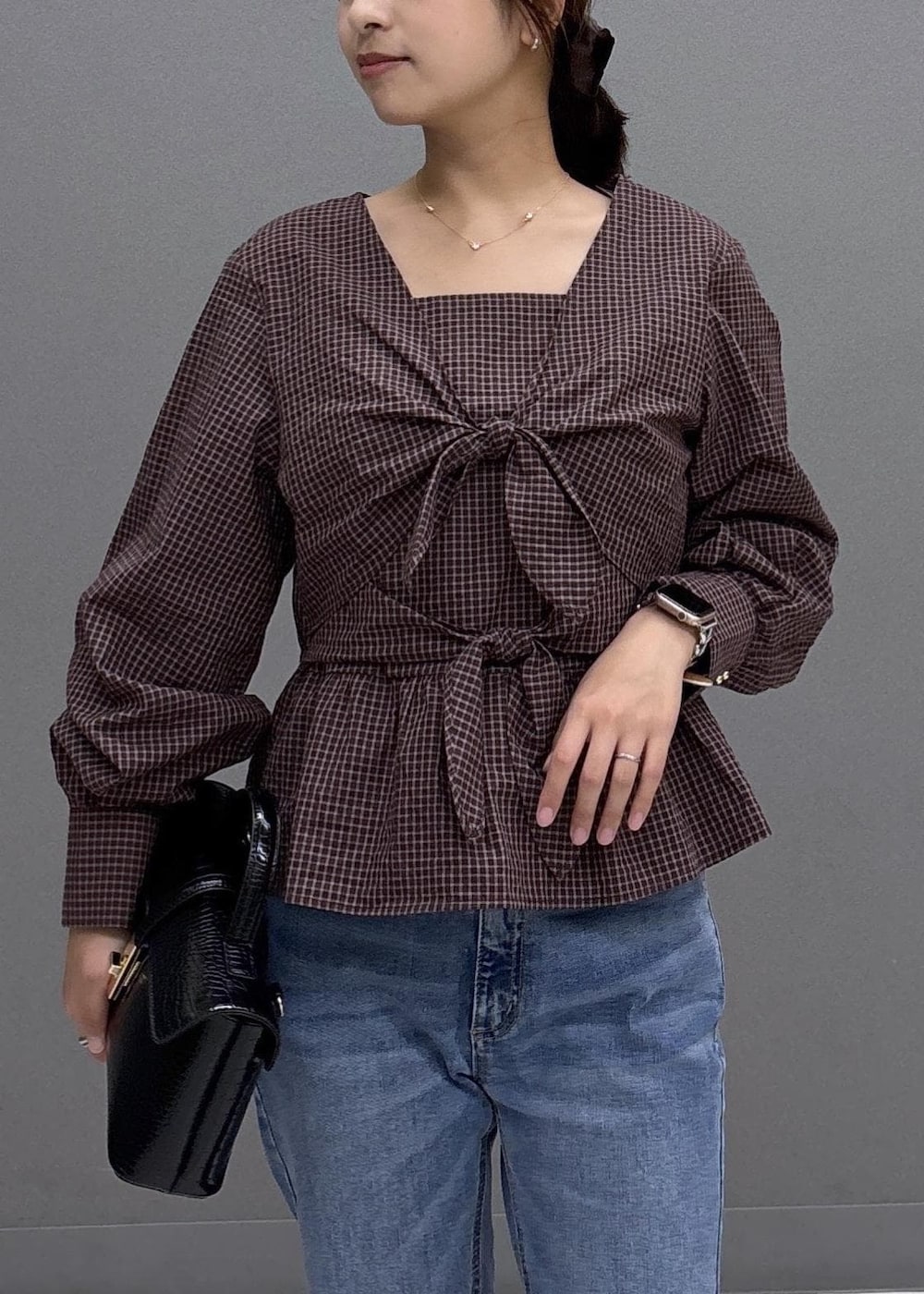 ブルー系のデニムパンツ、ブラック系のハンドバッグ、ブラック系のパンプスを着用したレディースの秋コーディネートの5枚目の写真