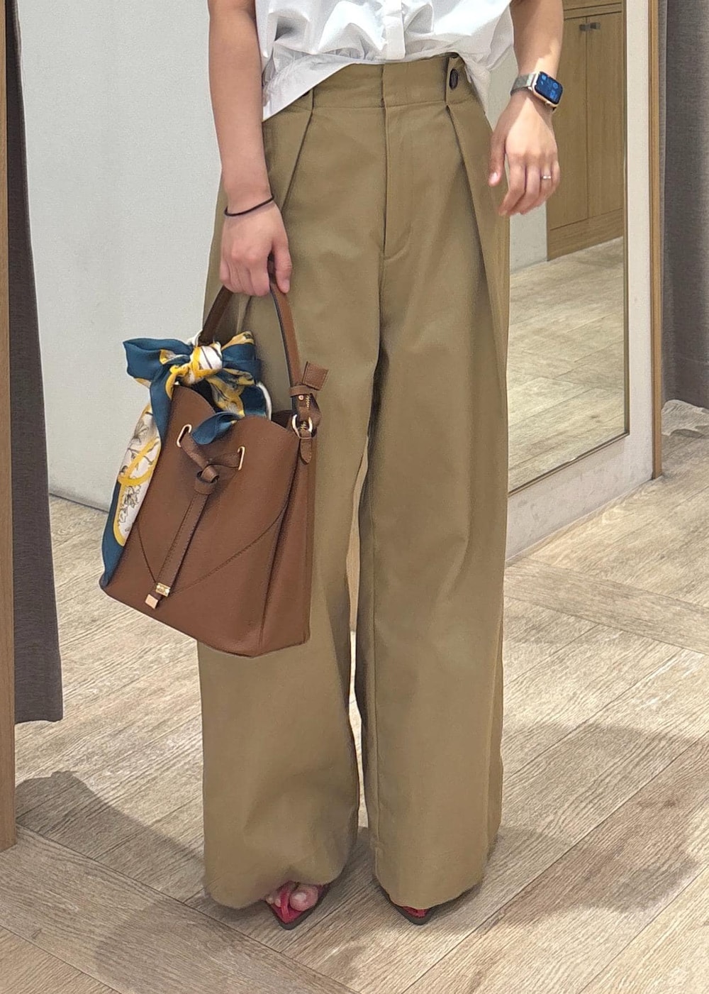 ブラウン系のショルダーバッグ、レッド系のサンダル、ホワイト系のシャツ/ブラウスを着用したレディースの夏コーディネートの5枚目の写真