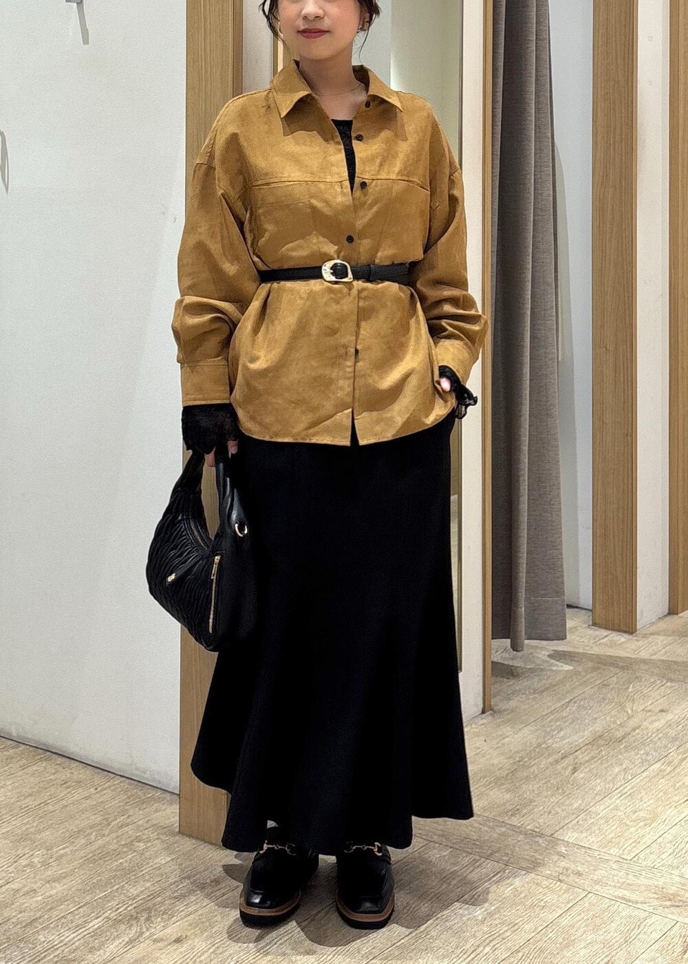 ブラック系のスカート、ブラック系のTシャツ/カットソー、ブラック系のハンドバッグを着用したレディースの秋コーディネートの9枚目の写真