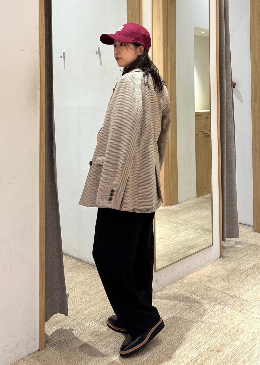 ブラウン系のショルダーバッグ、ベージュ系のテーラードジャケット、ベージュ系のキャミソールを着用したレディースの秋コーディネートの2枚目の写真