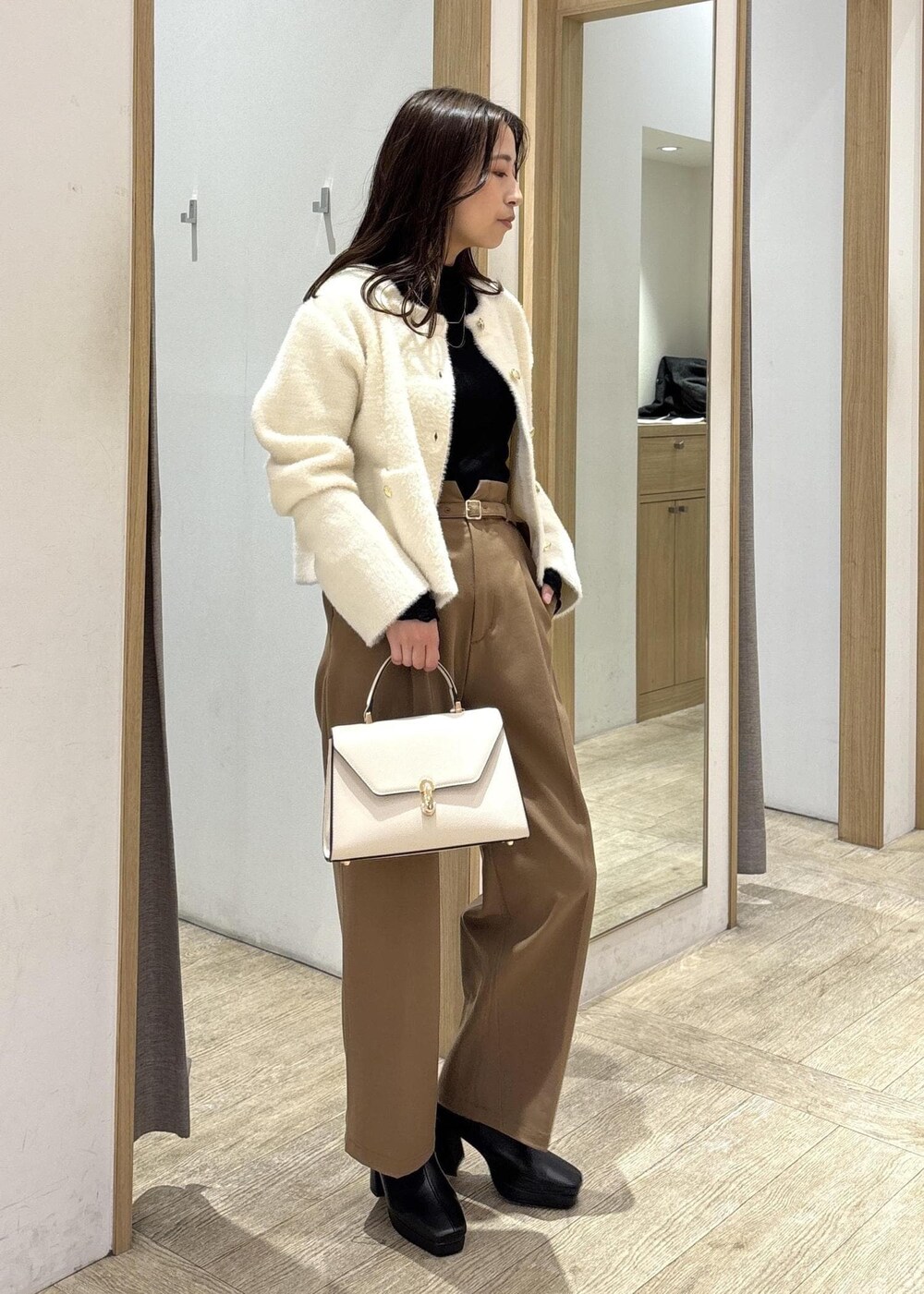 ホワイト系のカーディガン/ボレロ、ブラック系のTシャツ/カットソー、ブラック系のブーツを着用したレディースの秋コーディネートの2枚目の写真