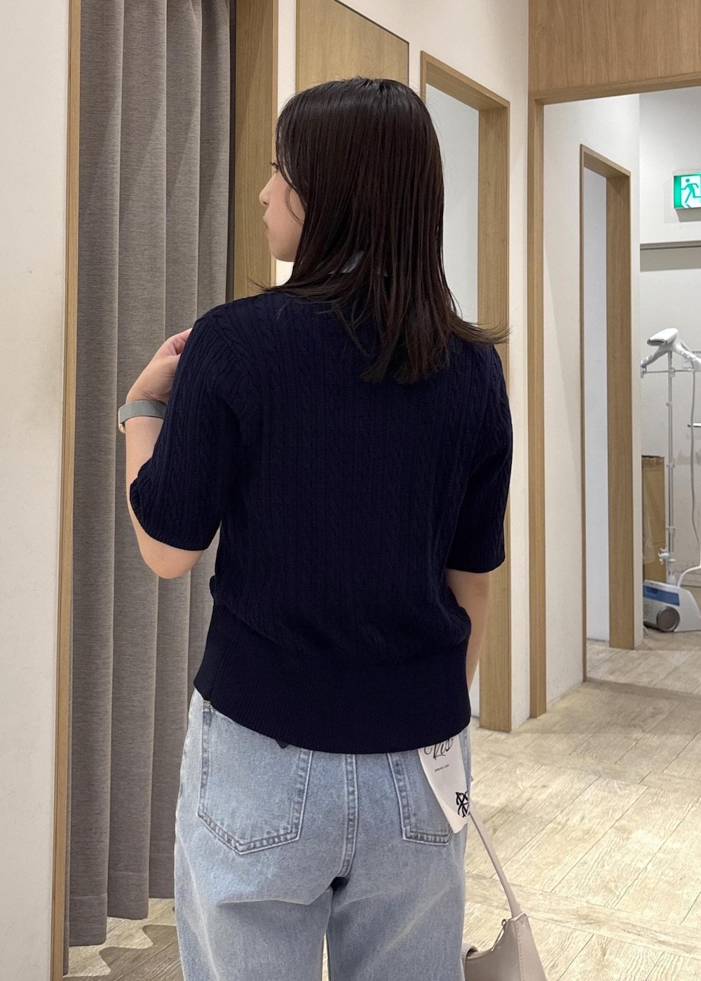 ホワイト系のショルダーバッグ、ホワイト系のパンプス、ブルー系のカーディガン/ボレロを着用したレディースの春コーディネートの7枚目の写真
