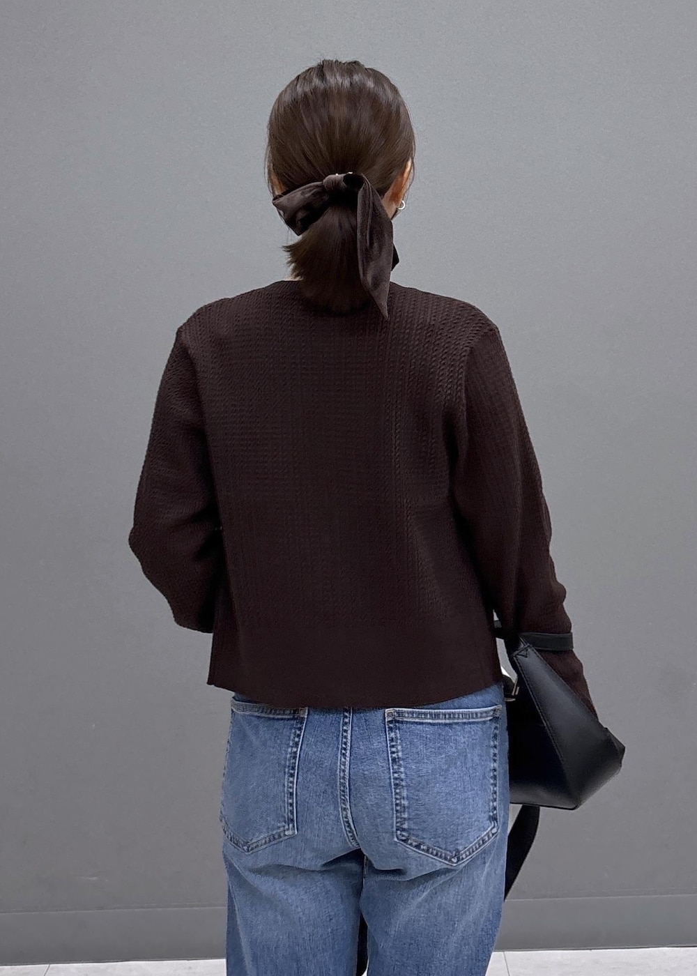 ブラック系のパンプス、ブルー系のデニムパンツ、ブラウン系のカーディガン/ボレロを着用したレディースの秋コーディネートの7枚目の写真
