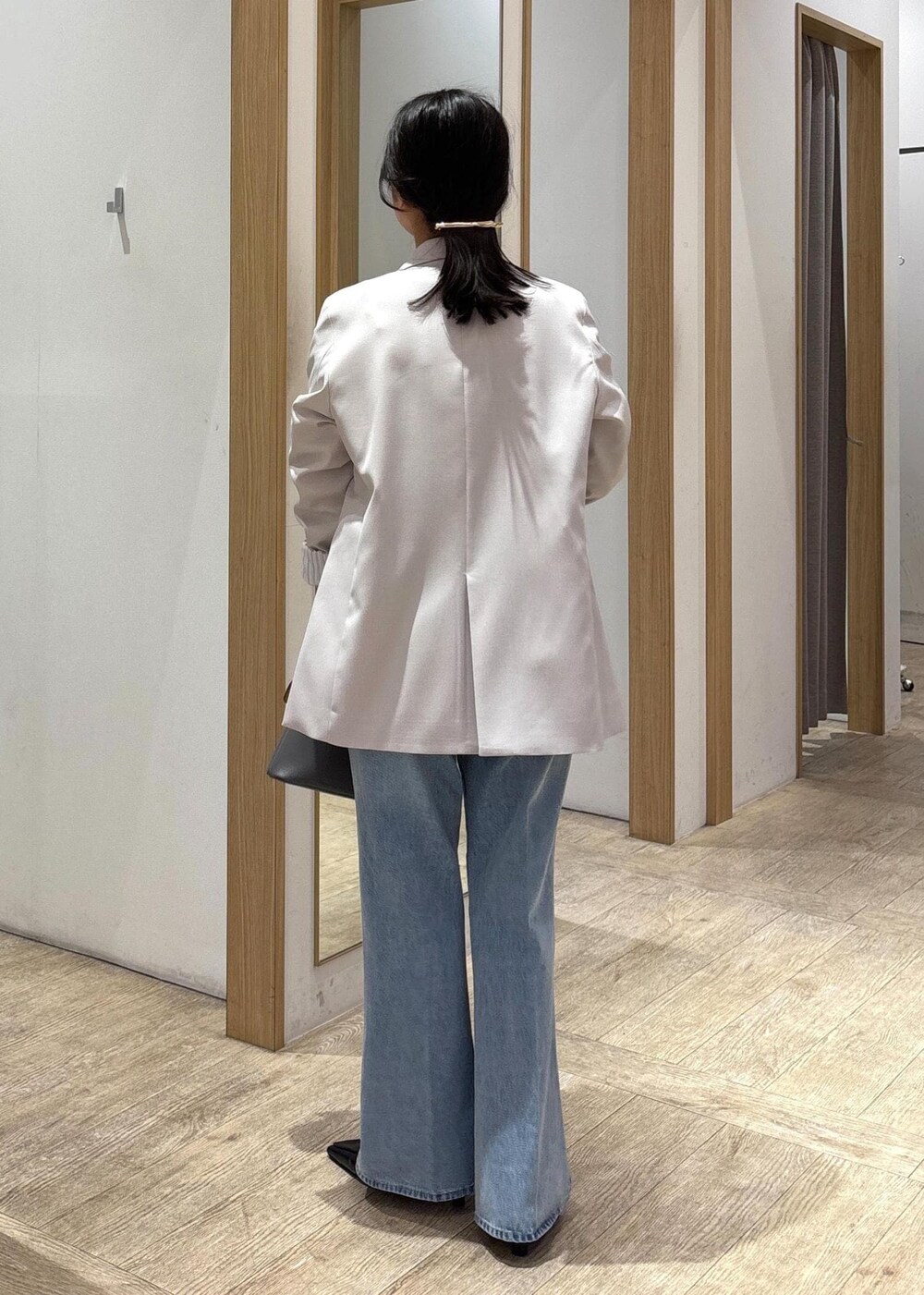 グレー系のショルダーバッグ、ベージュ系のテーラードジャケット、ブルー系のデニムパンツを着用したレディースの春コーディネートの4枚目の写真