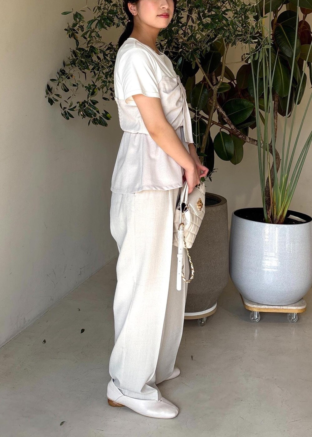 ホワイト系のパンプス、ホワイト系のTシャツ/カットソー、ホワイト系のスラックスを着用したレディースの春コーディネートの6枚目の写真