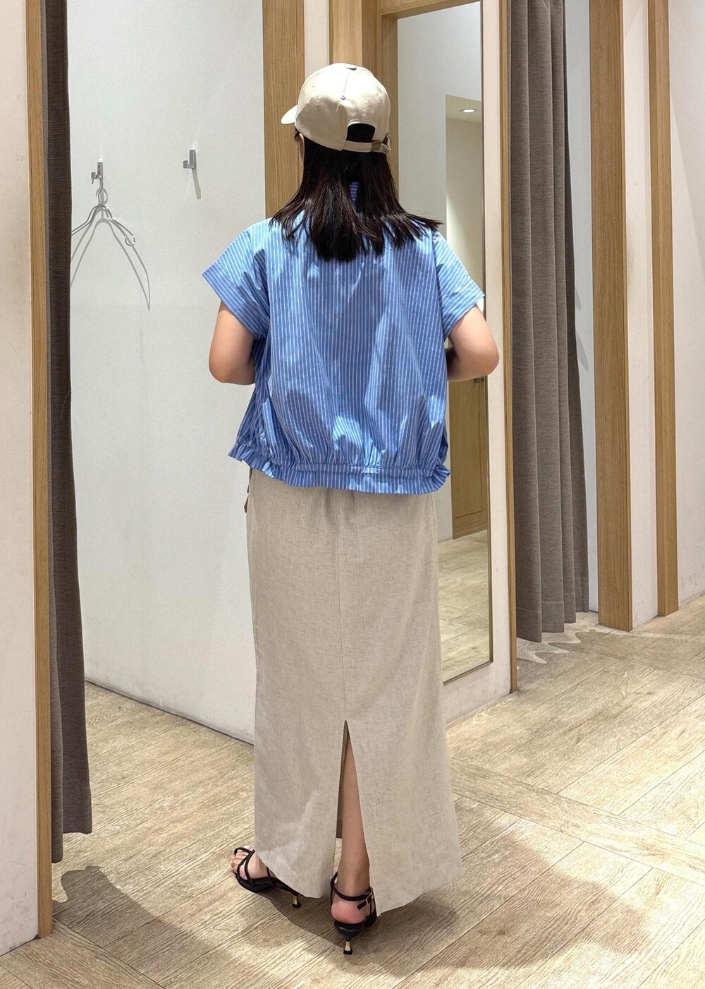 ブラック系のサンダル、ホワイト系のスカート、ブルー系のシャツ/ブラウスを着用したレディースの夏コーディネートの3枚目の写真