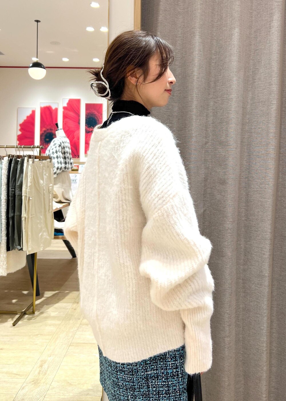 ブラック系のブーツ、ブルー系のスカート、ホワイト系のカーディガン/ボレロを着用したレディースの冬コーディネートの9枚目の写真