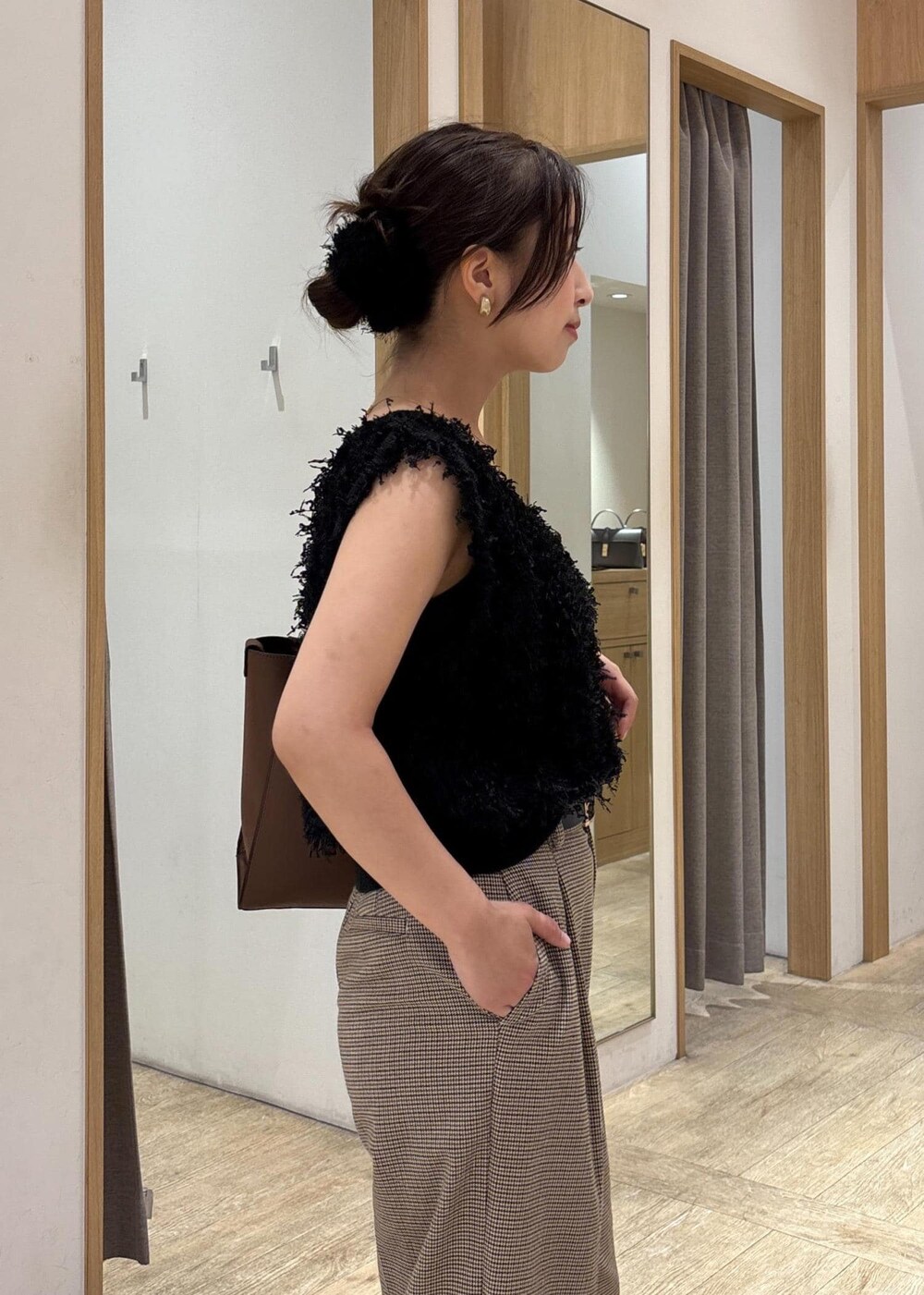 ブラック系のパンプス、ブラック系のベスト、ベージュ系のスラックスを着用したレディースの秋コーディネートの5枚目の写真