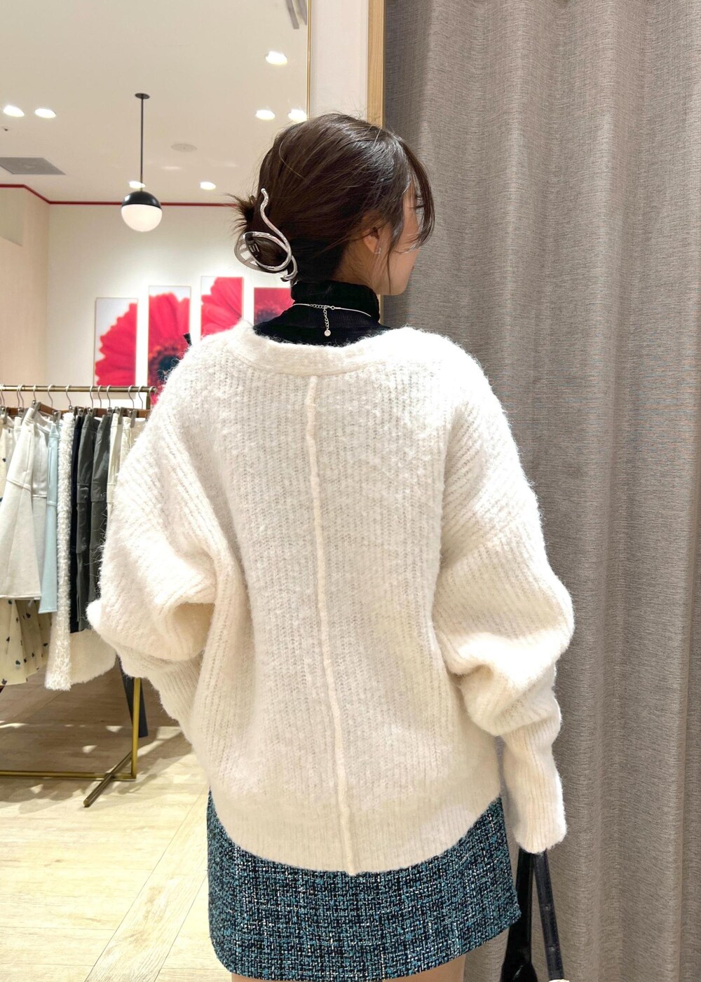 ブラック系のブーツ、ブルー系のスカート、ホワイト系のカーディガン/ボレロを着用したレディースの冬コーディネートの8枚目の写真