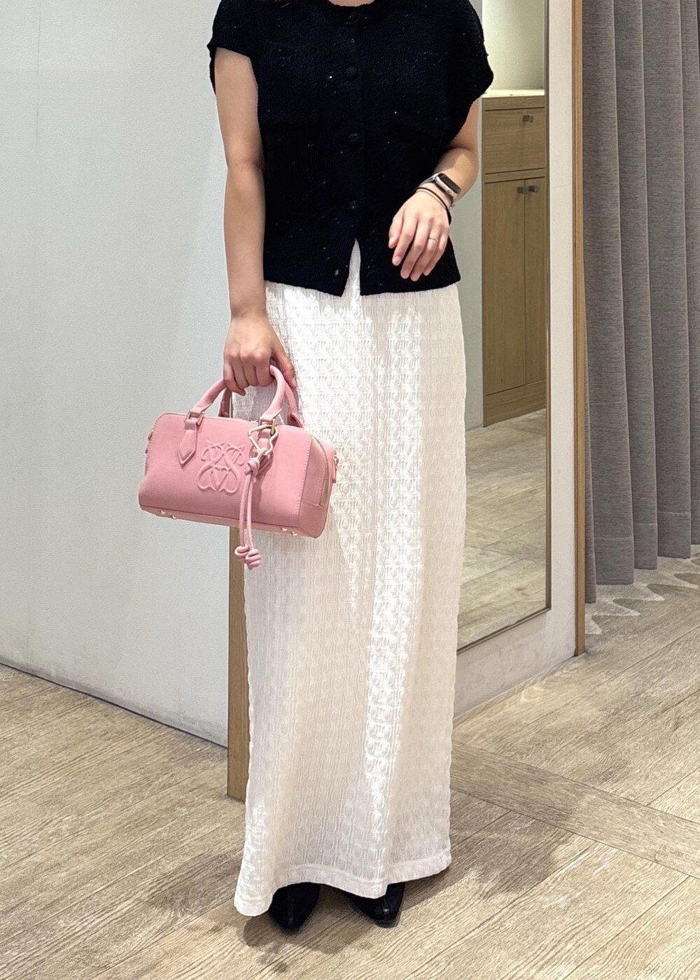 ホワイト系のスカート、ブラック系のカーディガン/ボレロ、ブラック系のパンプスを着用したレディースの夏コーディネートの8枚目の写真