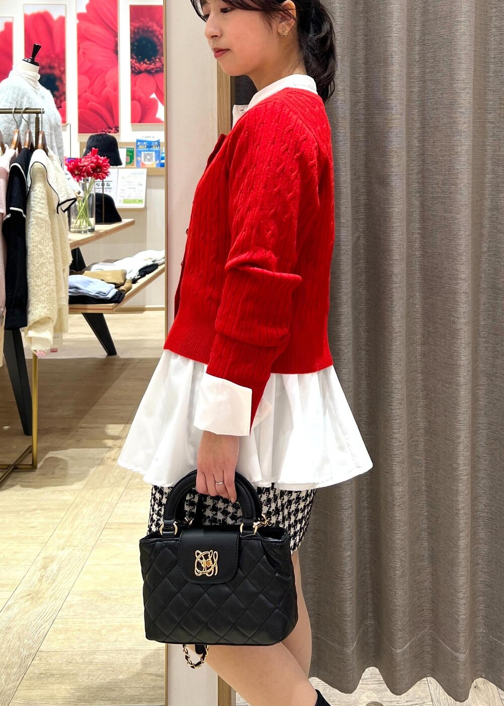 ブラック系のブーツ、ブラック系のスカート、ホワイト系のシャツ/ブラウスを着用したレディースの冬コーディネートの6枚目の写真