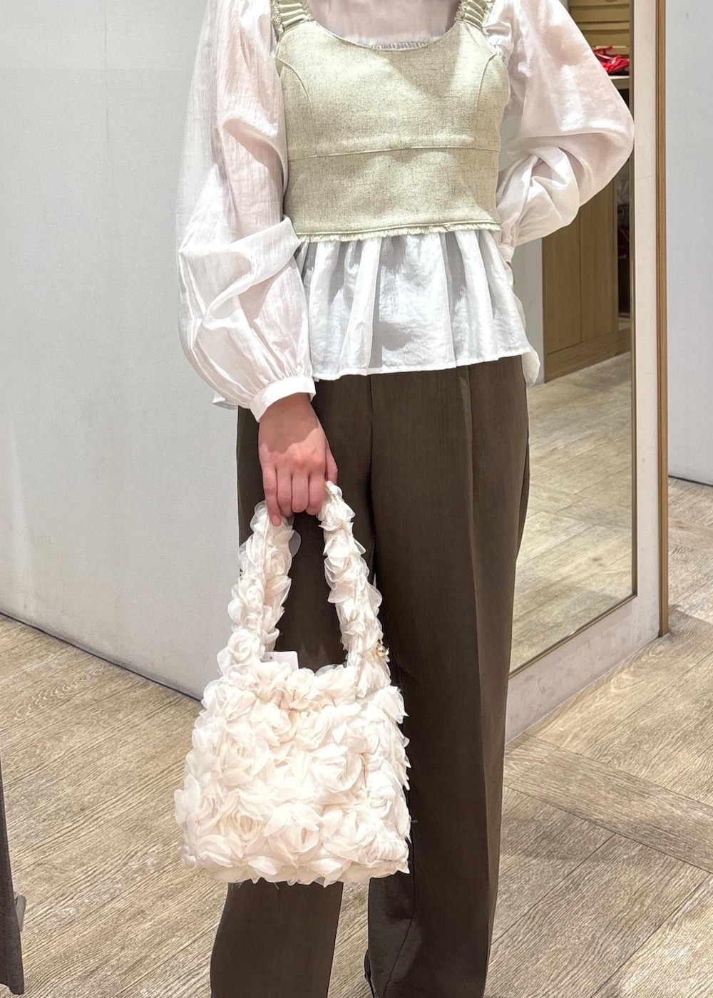 ホワイト系のシャツ/ブラウス、ブラック系のパンプス、ホワイト系のベストを着用したレディースの春コーディネートの5枚目の写真