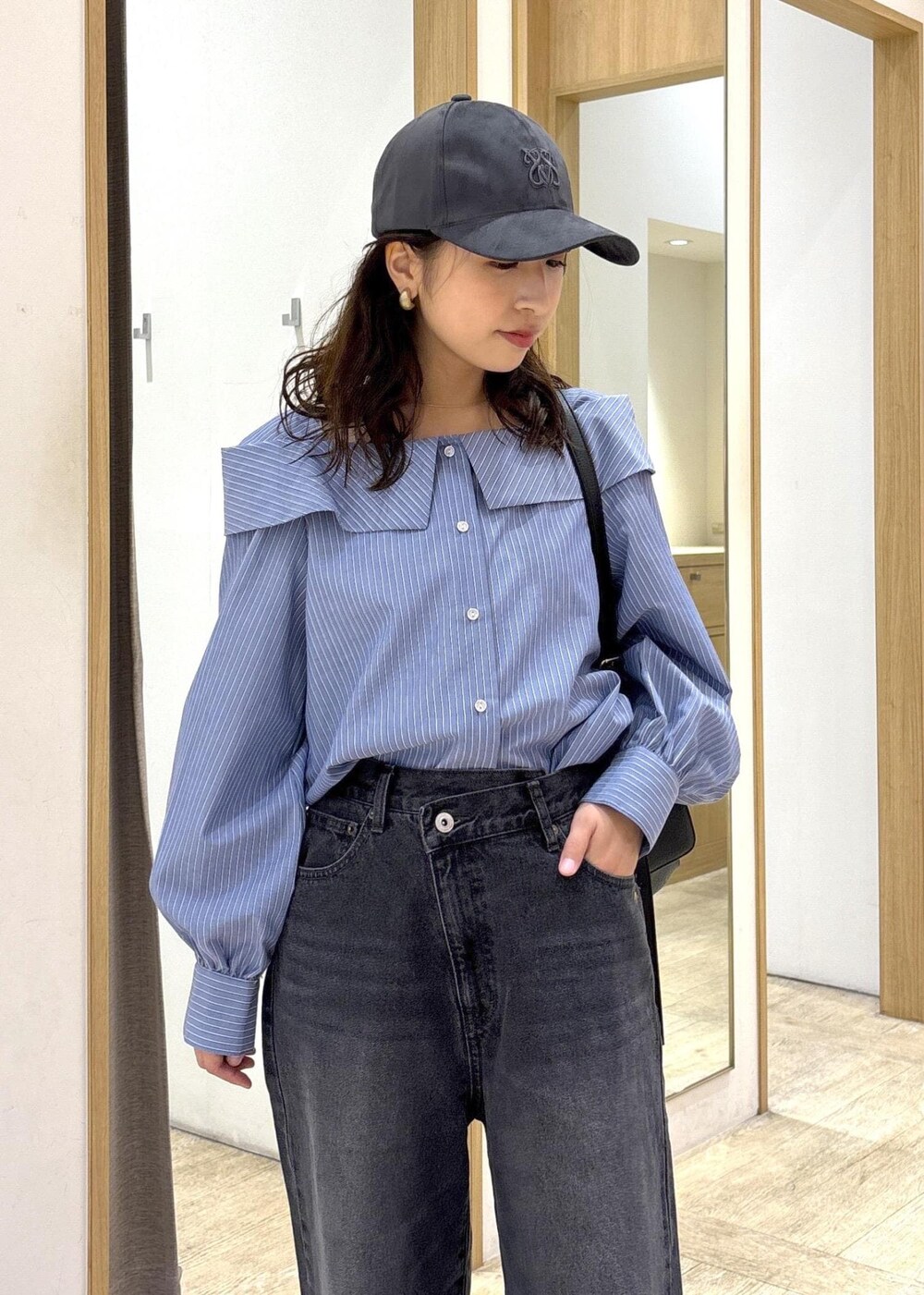 ブラック系のショルダーバッグ、ブラック系のローファー、ブルー系のシャツ/ブラウスを着用したレディースの秋コーディネートの5枚目の写真