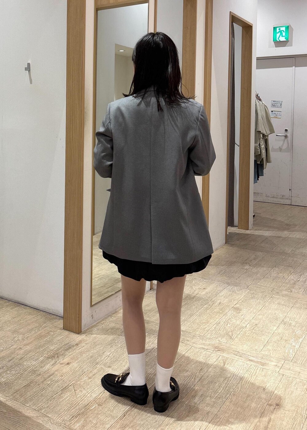 グレー系のテーラードジャケット、ブラック系のローファー、ブラック系のスカートを着用したレディースの春コーディネートの4枚目の写真