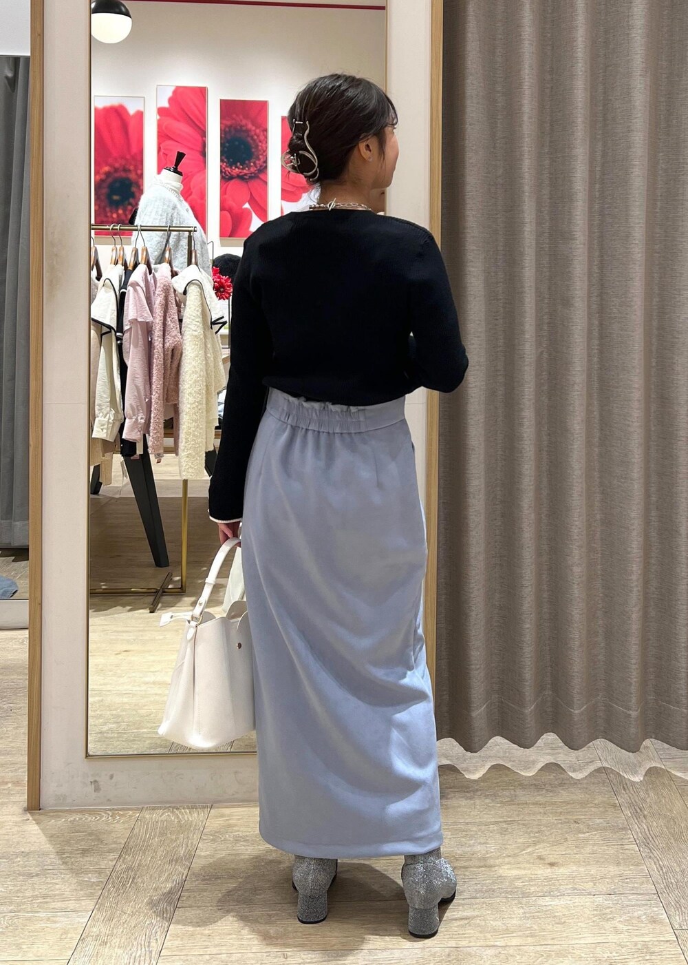 シルバー系のブーツ、ブルー系のスカート、ブラック系のニット/セーターを着用したレディースの冬コーディネートの5枚目の写真