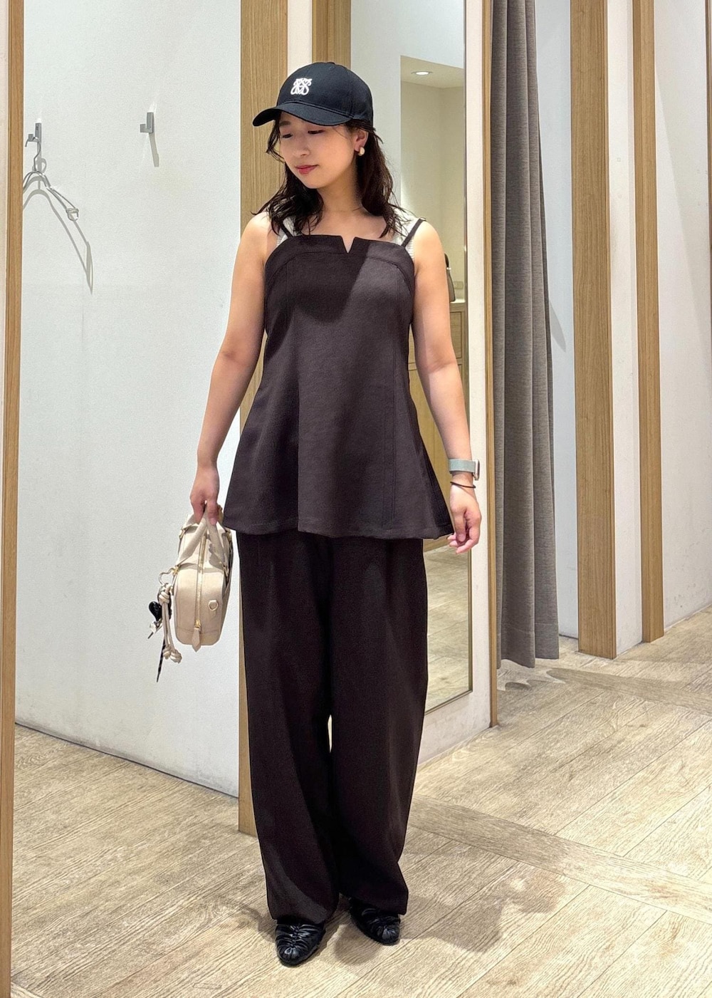 ベージュ系のボストンバッグ、ブラウン系のスラックス、ブラウン系のキャミソールを着用したレディースの秋コーディネートの8枚目の写真