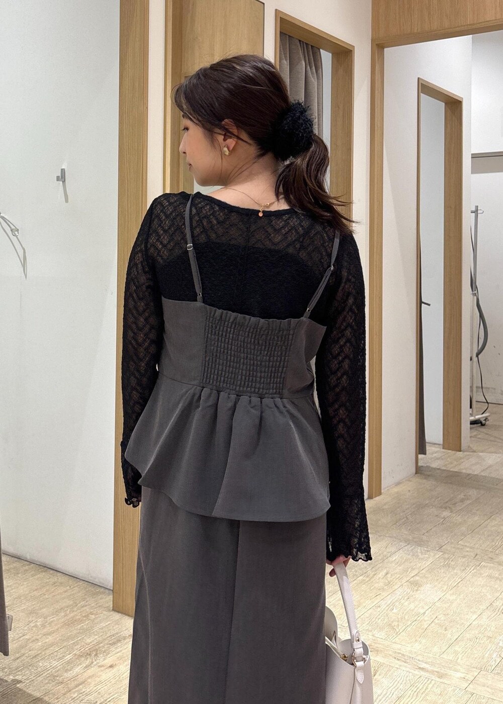 ホワイト系のショルダーバッグ、ブラック系のパンプス、グレー系のワンピースを着用したレディースの秋コーディネートの6枚目の写真