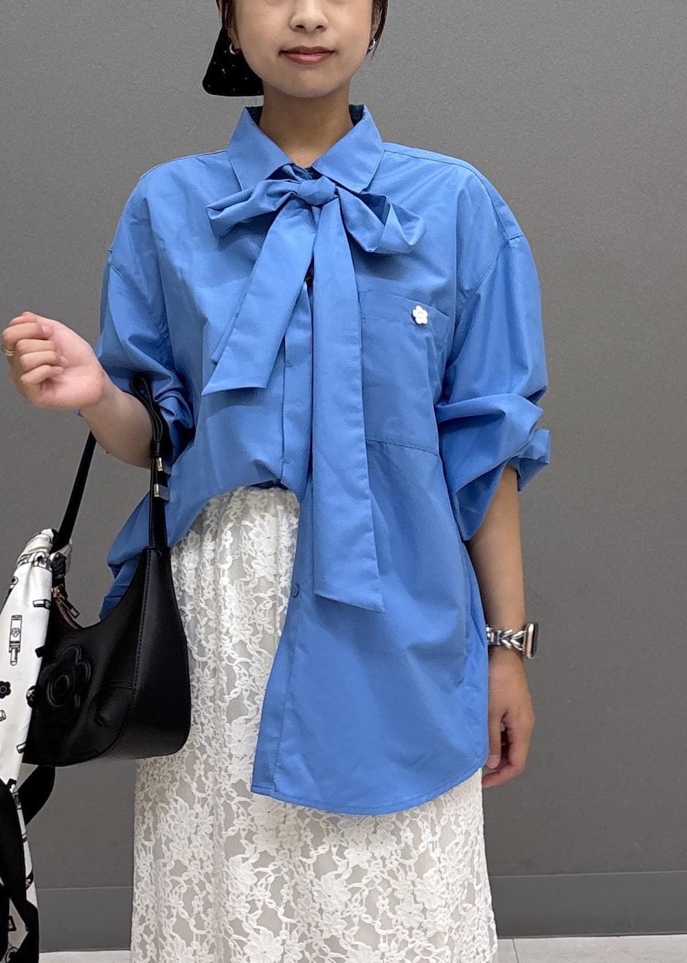 ブラック系のパンプス、ホワイト系のスカート、ブルー系のシャツ/ブラウスを着用したレディースの秋コーディネートの5枚目の写真