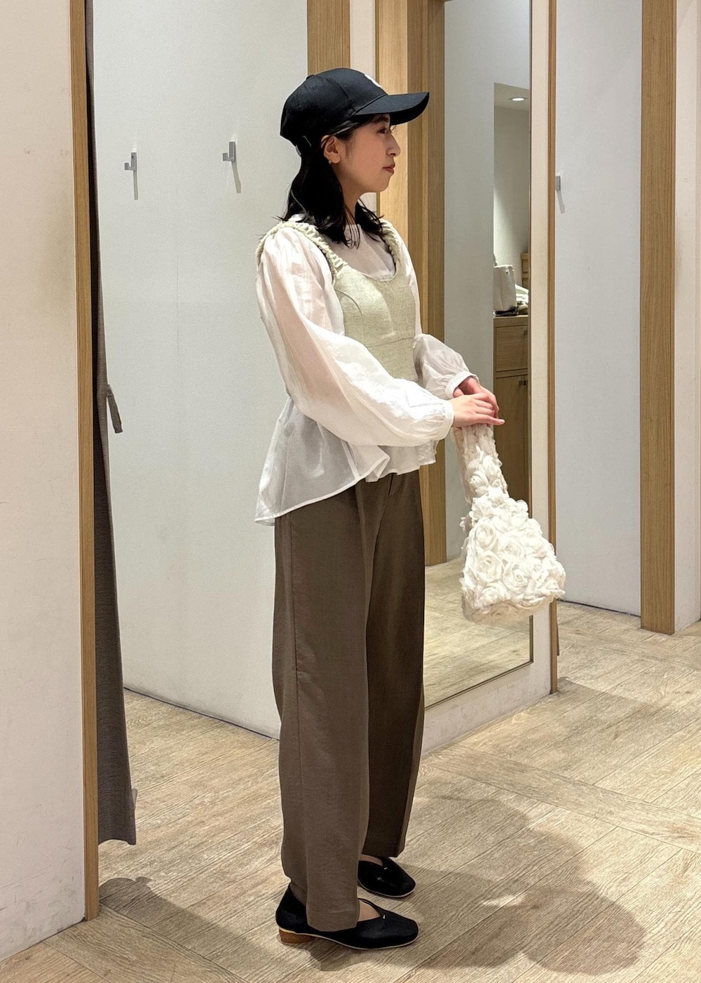 ホワイト系のシャツ/ブラウス、ブラック系のパンプス、ホワイト系のベストを着用したレディースの春コーディネートの4枚目の写真