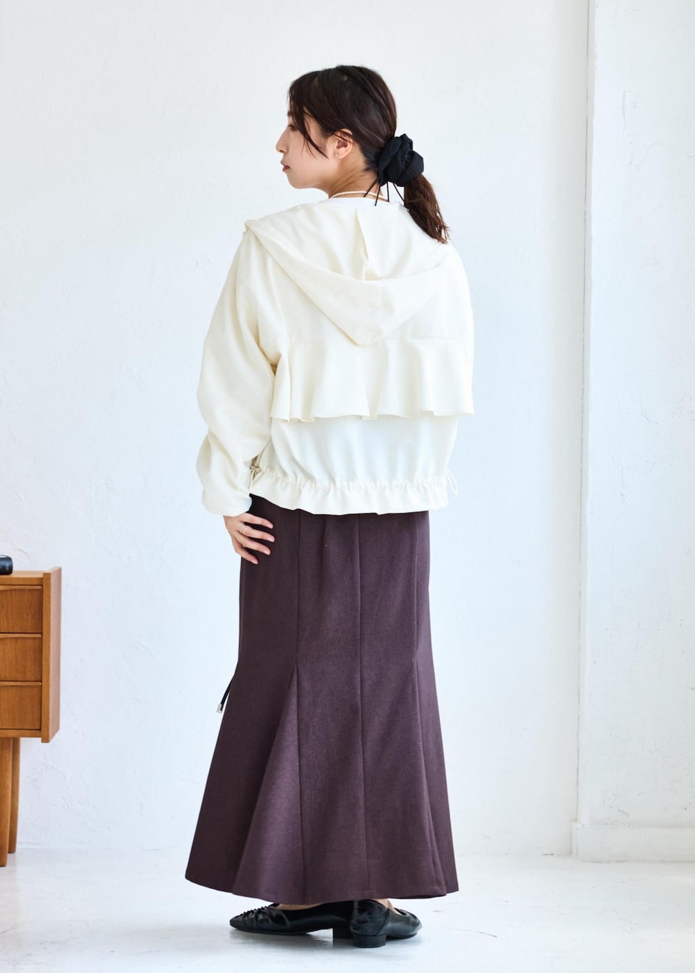 ホワイト系のショルダーバッグ、ブラウン系のスカート、ホワイト系のTシャツ/カットソーを着用したレディースの夏コーディネートの3枚目の写真