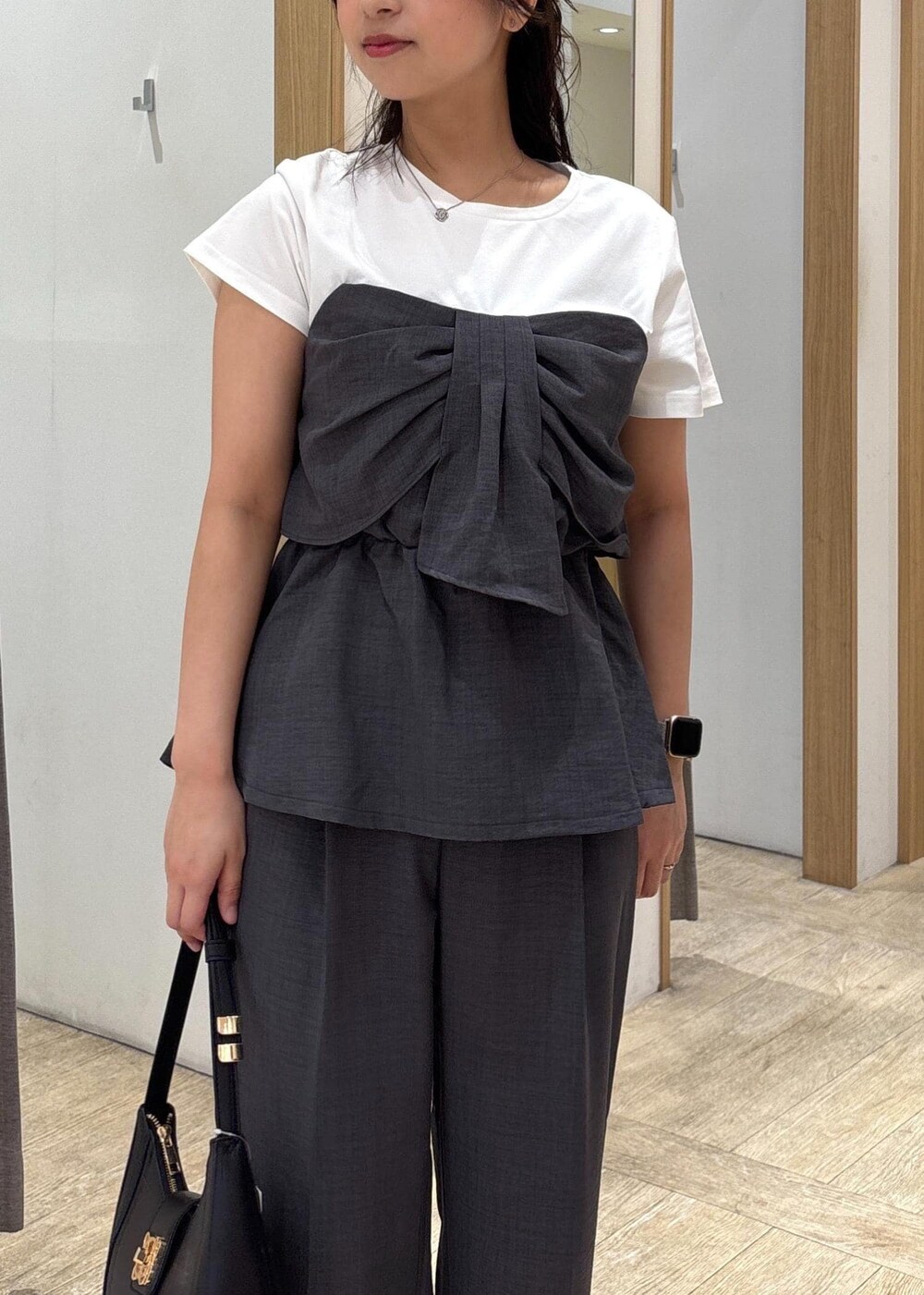 ブラック系のサンダル、グレー系のTシャツ/カットソー、グレー系のスラックスを着用したレディースの夏コーディネートの5枚目の写真