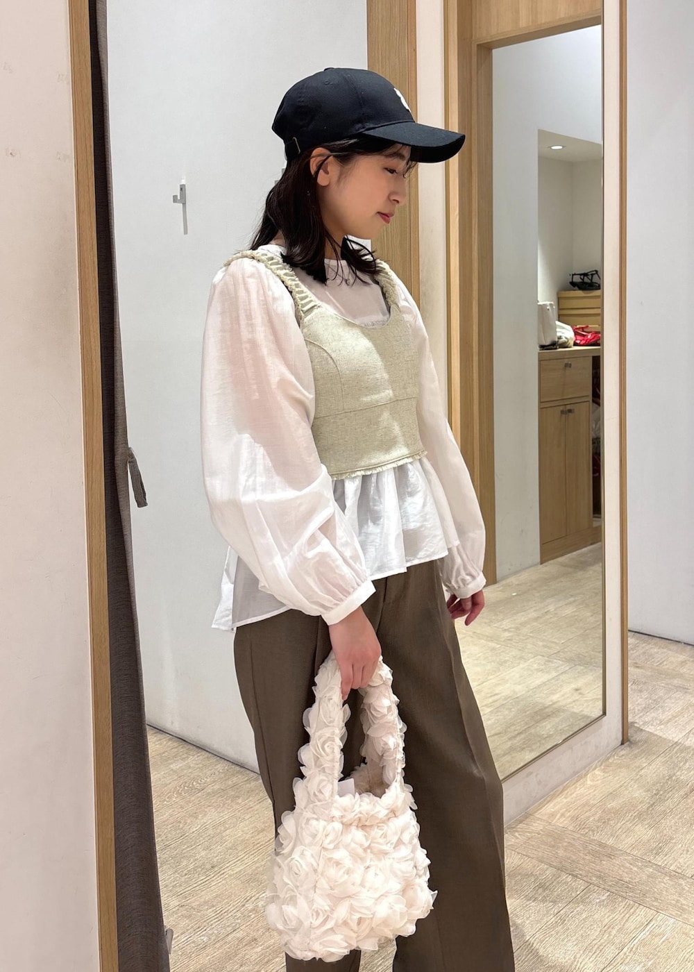 ホワイト系のシャツ/ブラウス、ブラック系のパンプス、ホワイト系のベストを着用したレディースの春コーディネートの6枚目の写真