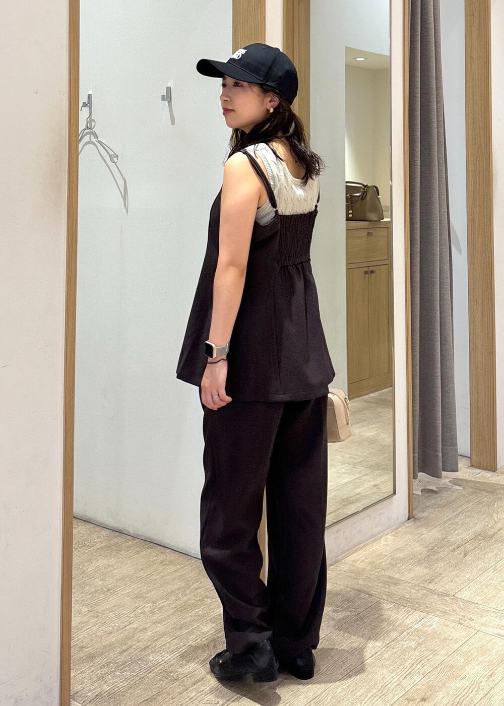 ベージュ系のボストンバッグ、ブラウン系のスラックス、ブラウン系のキャミソールを着用したレディースの秋コーディネートの2枚目の写真