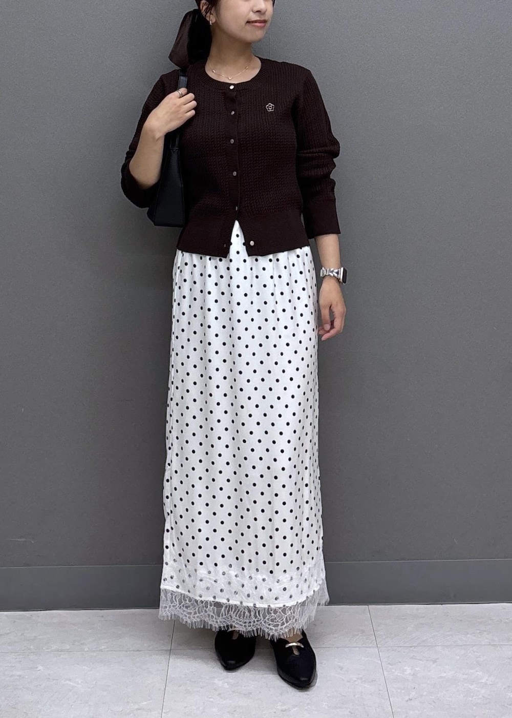 ブラック系のパンプス、ホワイト系のスカート、ブラウン系のカーディガン/ボレロを着用したレディースの秋コーディネートの10枚目の写真